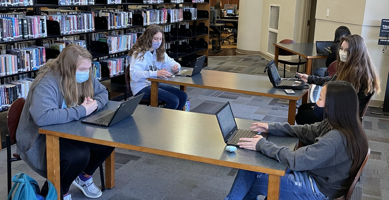 Students presenting projects in a library at BHS